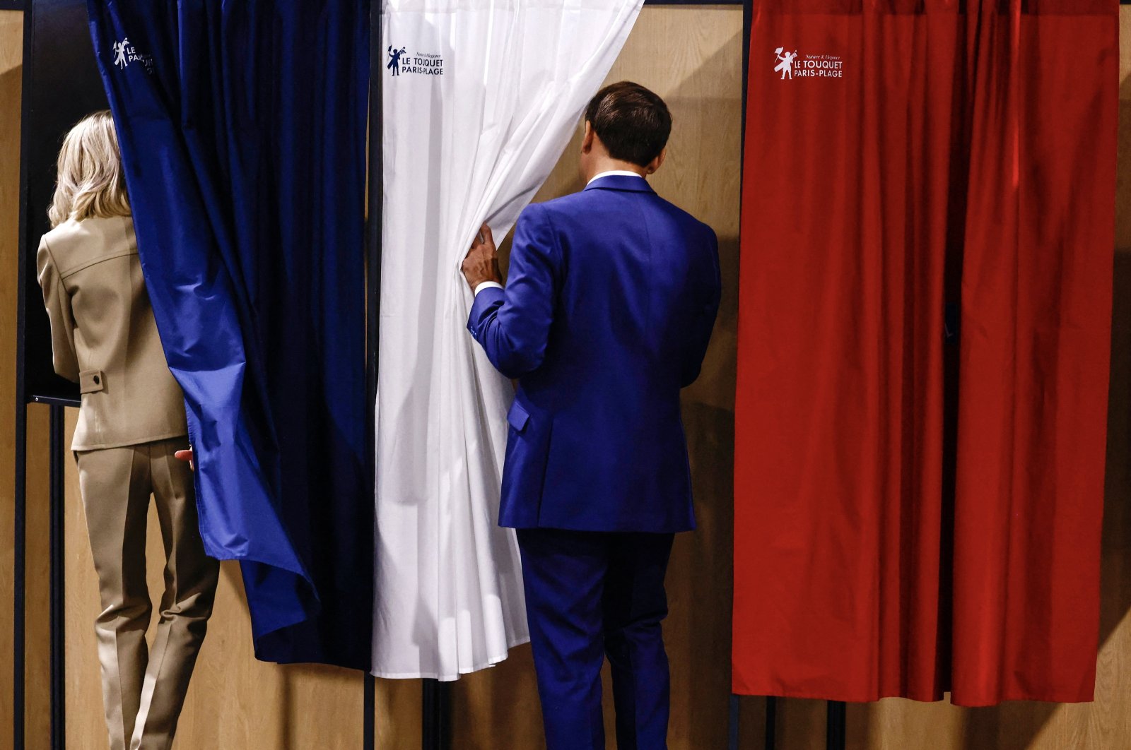 French President Emmanuel Macron (R) and his wife Brigitte Macron enter voting booths, in Le Touquet-Paris-Plage, France, June 30, 2024. (EPA Photo)