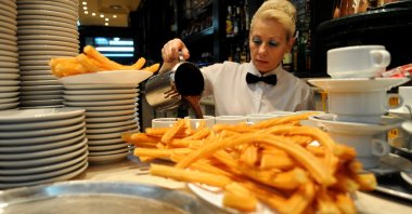 A waitress pours hot chocolate into cups to be served with Churros at the San Gines Chocolateria, Madrid, Spain, Oct. 23, 2009. (Getty Images Photo)