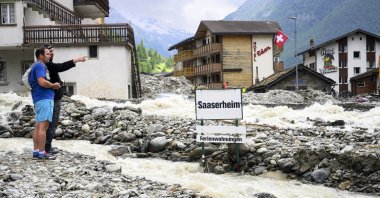 People stand next to rubble from a landslide following storms that caused major flooding in Saas-Grund, Switzerland, June 30, 2024. (EPA Photo)