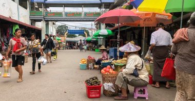 A vegetable vendor waits for customers at a market in Lashio in Myanmar's northern Shan State, June 18, 2024. (AFP Photo)