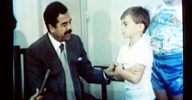 In this undated 1990 file photo, Iraqi President Saddam Hussein, speaks with British hostages in an image made from Iraqi TV. (AP Photo)