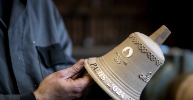 Alois Huguenin holds a Olympic Games bell in his foundry, La Chaux-de-Fonds, Neuchatel, Switzerland, May 8, 2024. (AFP Photo)