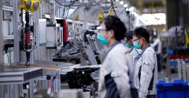 Employees wearing face masks work on a car seat assembly line at Yanfeng Adient factory, Shanghai, China, Feb. 24, 2020. (Reuters Photo)