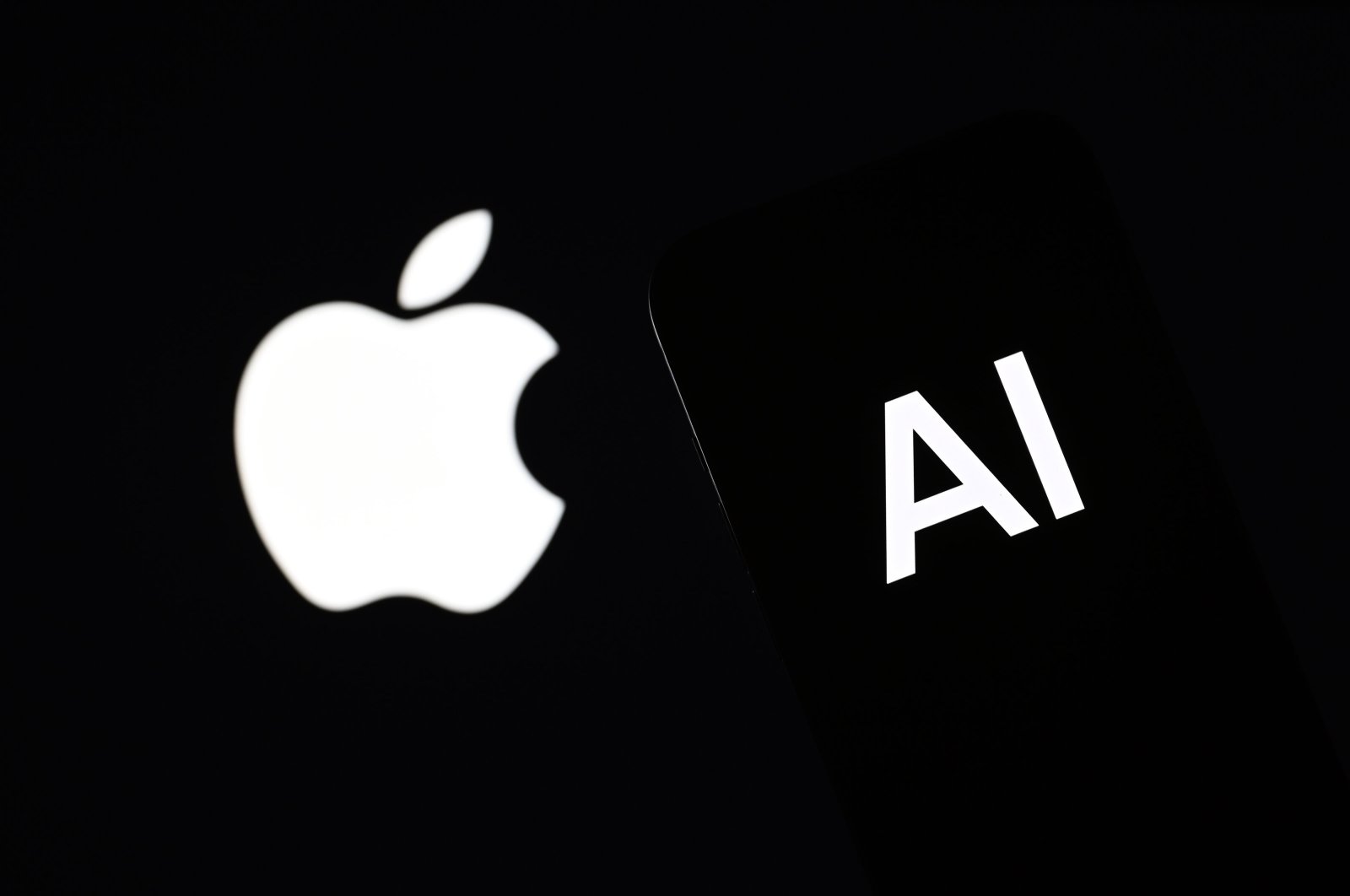 The Apple logo is displayed alongside an AI logo on a smartphone screen in this photo illustration, June 10, 2024. (AA Photo)