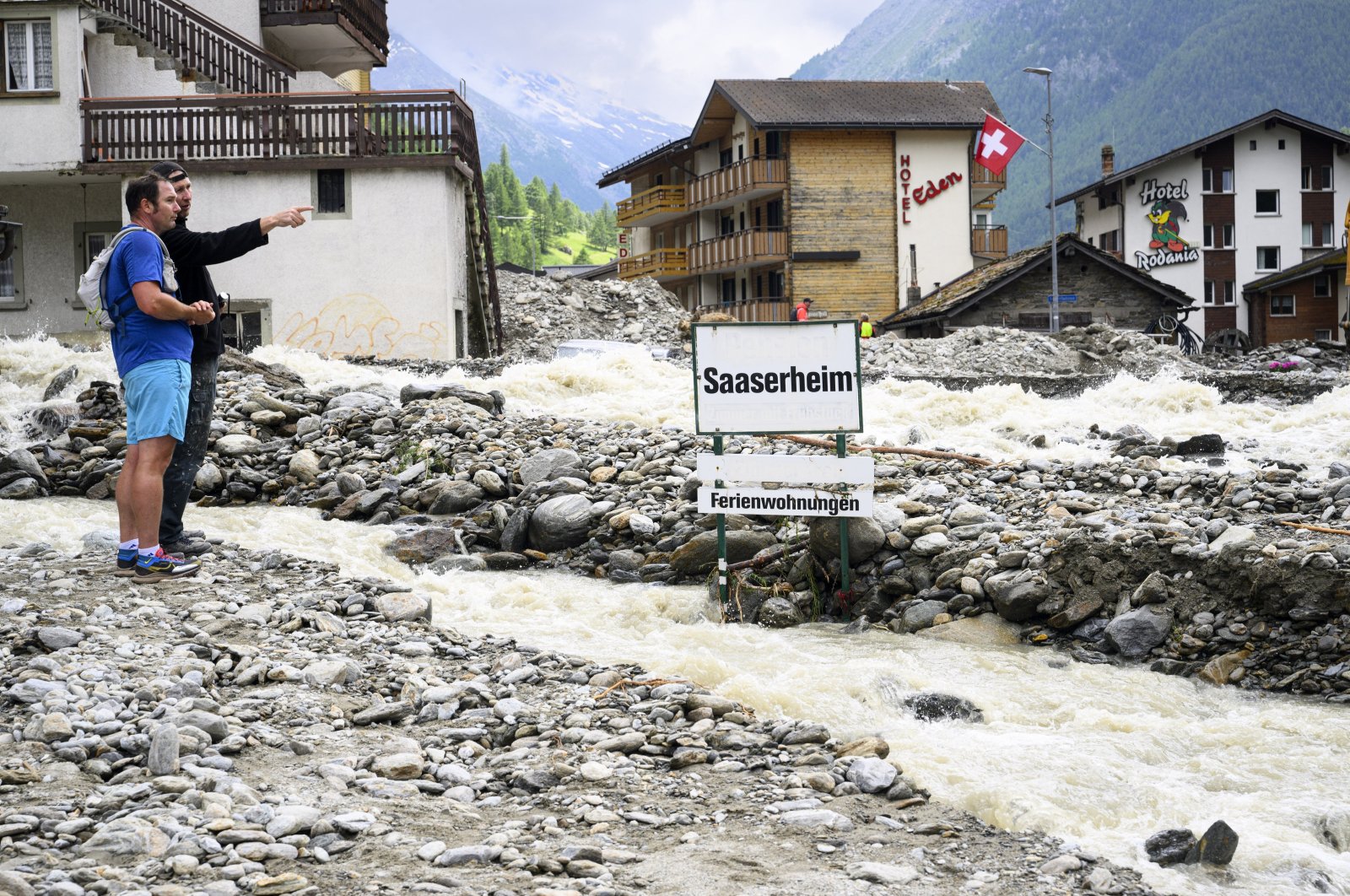 People stand next to rubble from a landslide following storms that caused major flooding in Saas-Grund, Switzerland, June 30, 2024. (EPA Photo)