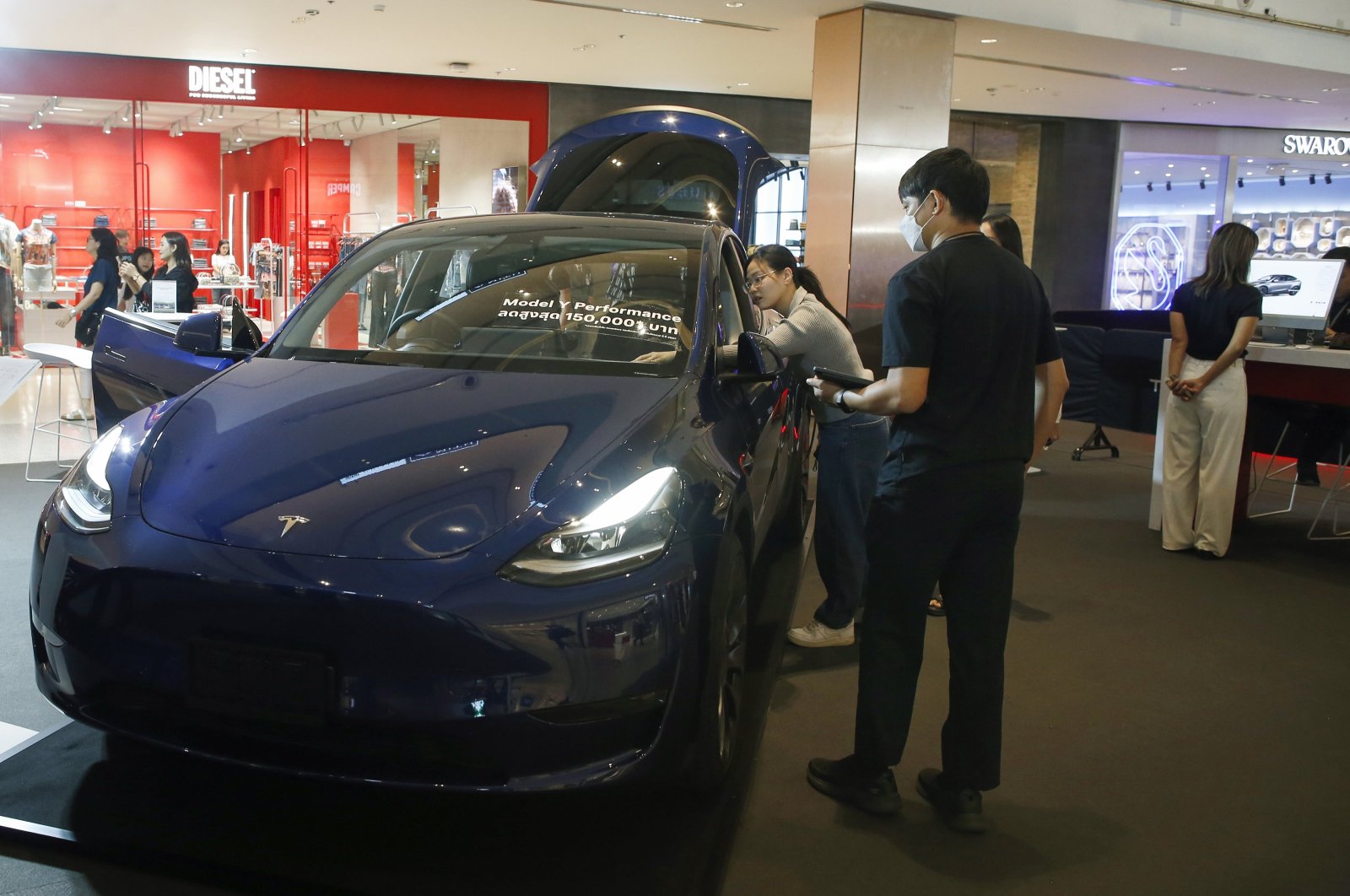 Visitors inspect a Tesla Model Y electric car displayed for sale at a shopping mall in Bangkok, Thailand, June 24, 2024. (EPA Photo)