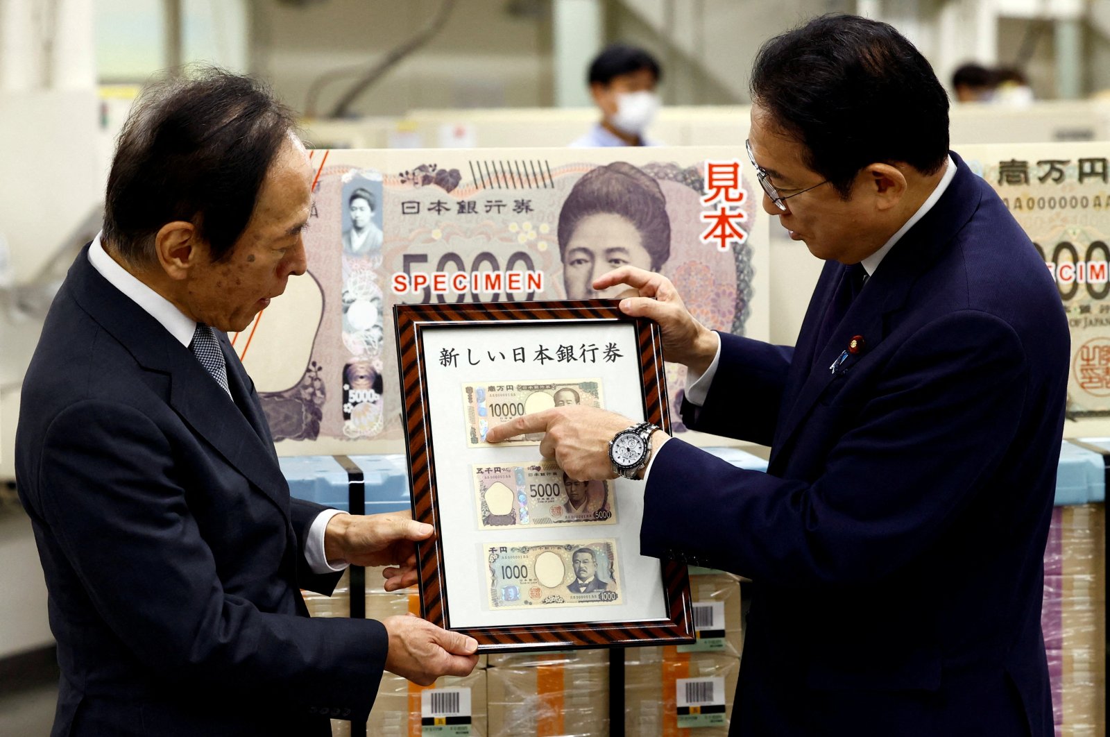 Japanese Prime Minister Fumio Kishida (R) looks at the new banknotes with Bank of Japan (BOJ) Governor Kazuo Ueda, on the day of the new notes of 10,000 yen, 5,000 yen and 1,000 yen went into circulation, BOJ headquarters, Tokyo, Japan, July 3, 2024. (Reuters Photo)