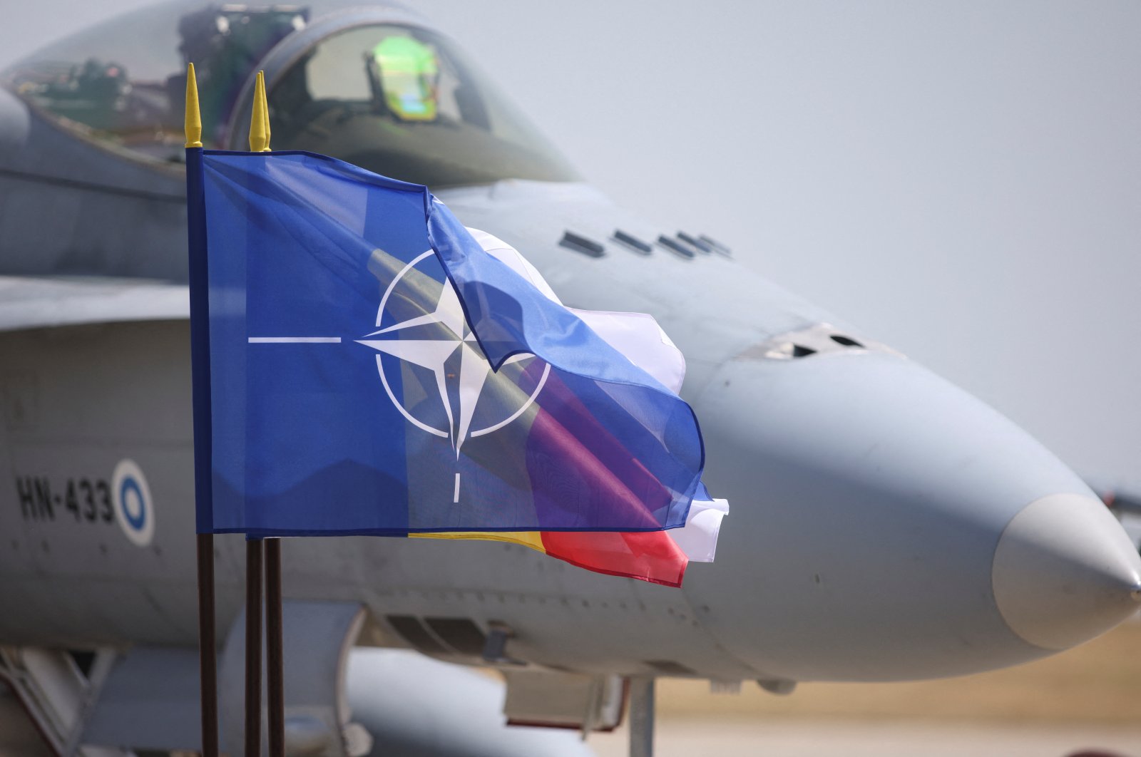 A Finnish Air Force F/A-18 fighter plane is seen near a NATO flag during the certification ceremony taking place at Mihail Kogalniceanu Air Base, Constanta, Romania, June 11, 2024. (Reuters Photo)