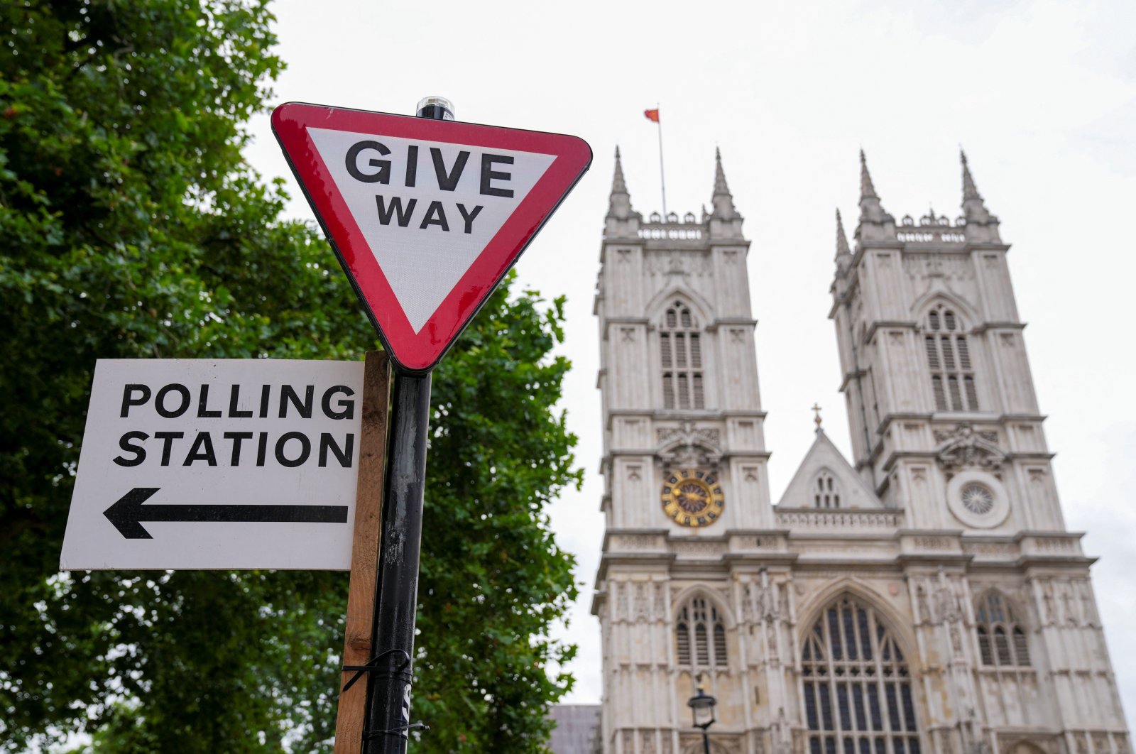 A polling station direction sign is attached to a street sign near Westminster Abbey, ahead of general elections, London, U.K., July 3, 2024. (Reuters Photo)