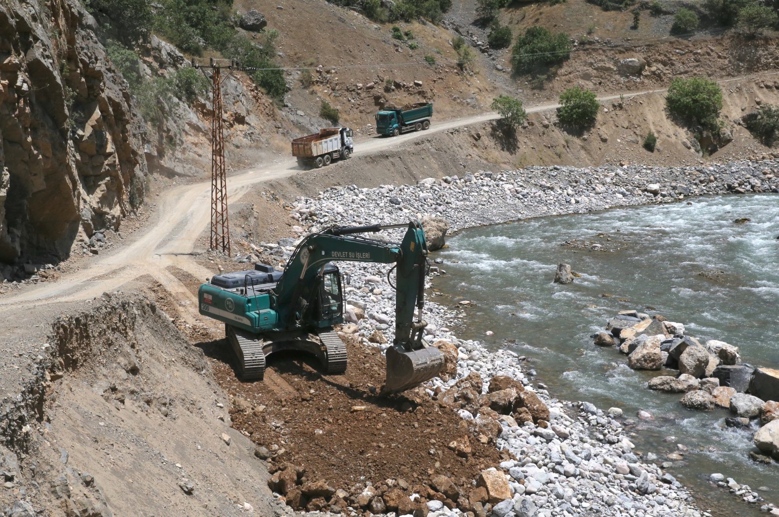 Bulldozers and trucks work on a road in Çukurca district, Hakkari, southeastern Türkiye, July 3, 2024. (AA Photo)