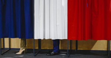 French President Emmanuel Macron and his wife, Brigitte Macron, stand in the voting booth before voting, Le Touquet-Paris-Plage, northern France, June 30, 2024. (AP Photo)