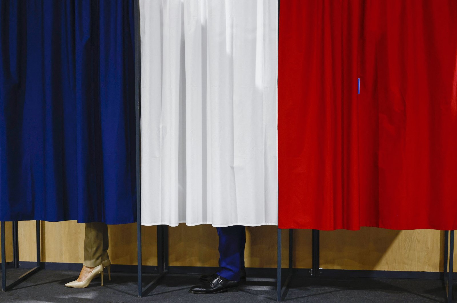 French President Emmanuel Macron and his wife, Brigitte Macron, stand in the voting booth before voting, Le Touquet-Paris-Plage, northern France, June 30, 2024. (AP Photo)