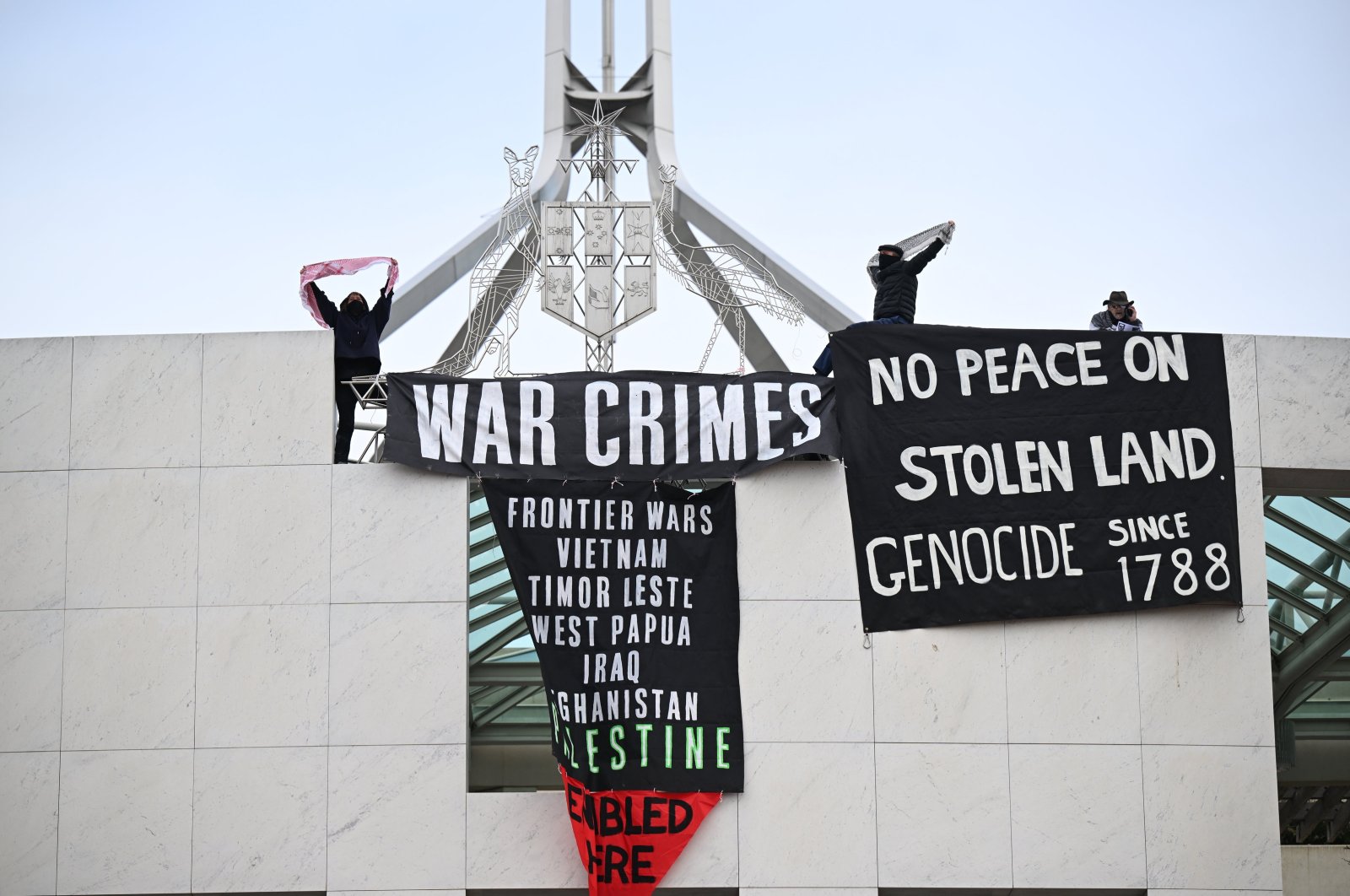 Pro-Palestine protesters hang banners from the top of Parliament House in Canberra, Australia, July 4, 2024. (EPA Photo)