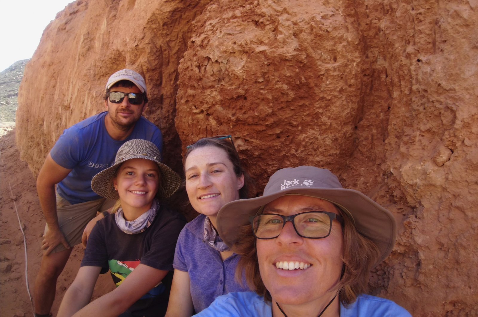 Michele Francis (R) and other researchers pose for a selfie next to an ancient termite mound in Namaqualand, South Africa, Sept. 15, 2018. (AP Photo)