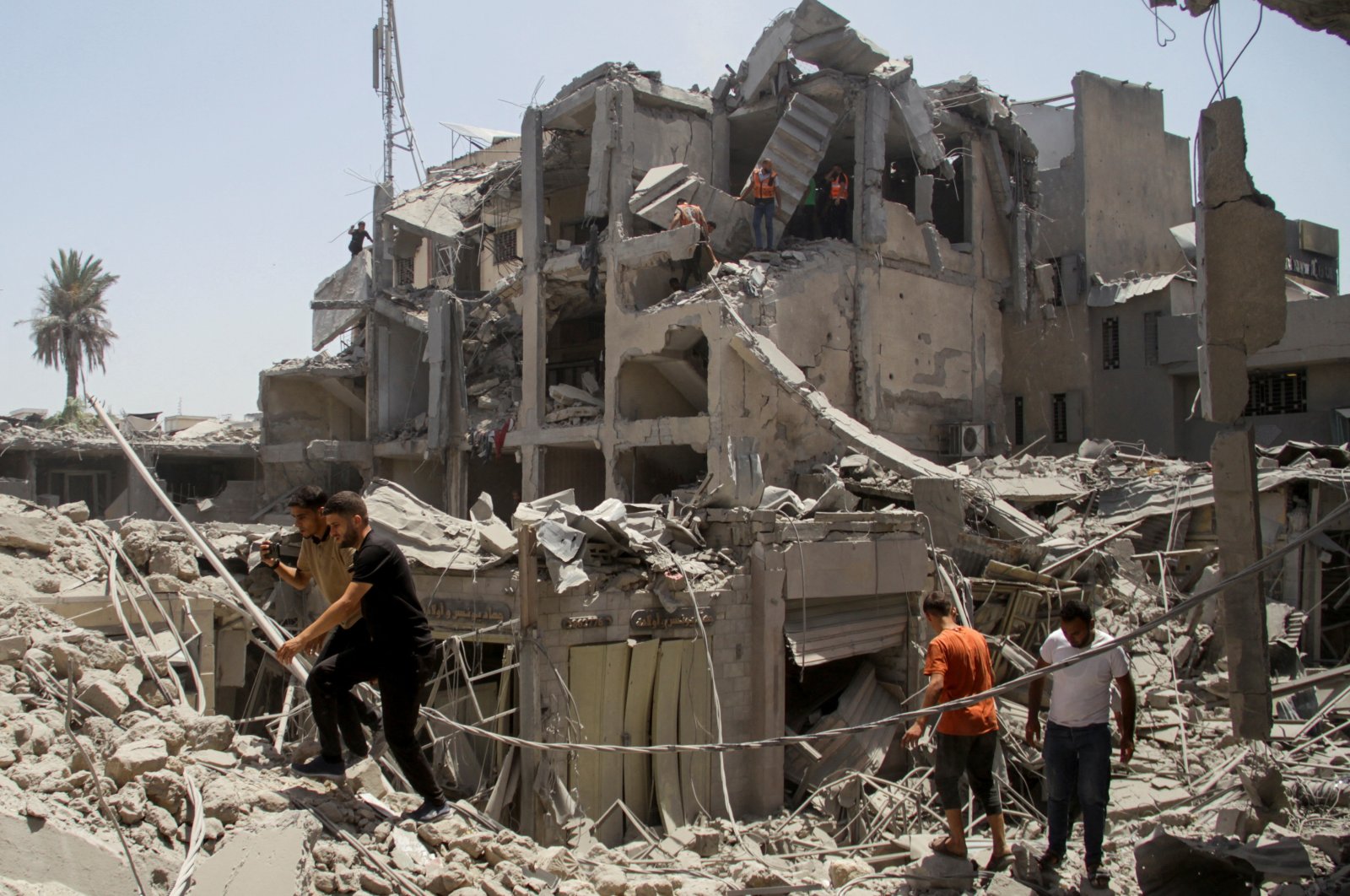 Palestinians walk at the site of Israeli strikes that hit a residential building and destroyed shops at Gaza&#039;s Old City market, Gaza, Palestine, July 4, 2024. (Reuters Photo)