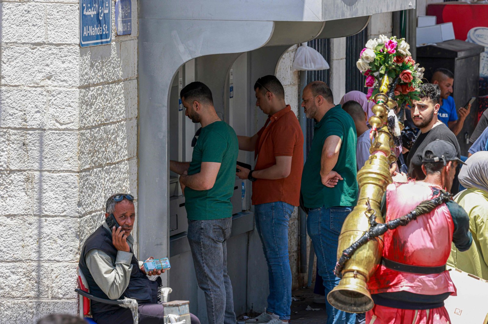 Palestinians queue to withdraw money from an ATM in the main market in Ramallah city in the Israel-occupied West Bank, June 9, 2024. (AFP Photo)