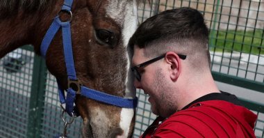 Matteo Santopadre, a former shooting champion who remained in a coma for months after a car accident, attends a hippotherapy session to regain his mobility, Rome, Italy, March 13, 2024. (Reuters Photo)