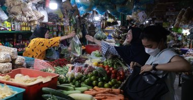 A produce vendor serves customers at a market, Depok, Indonesia, July 1, 2024. (EPA Photo)