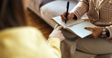 An older woman with training in problem-solving therapy patiently sits, ready to listen and engage in a one-on-one conversation. The therapy is inspired by a traditional practice in Zimbabwe in which grandmothers were the go-to people for wisdom in rough times. (Getty Images)