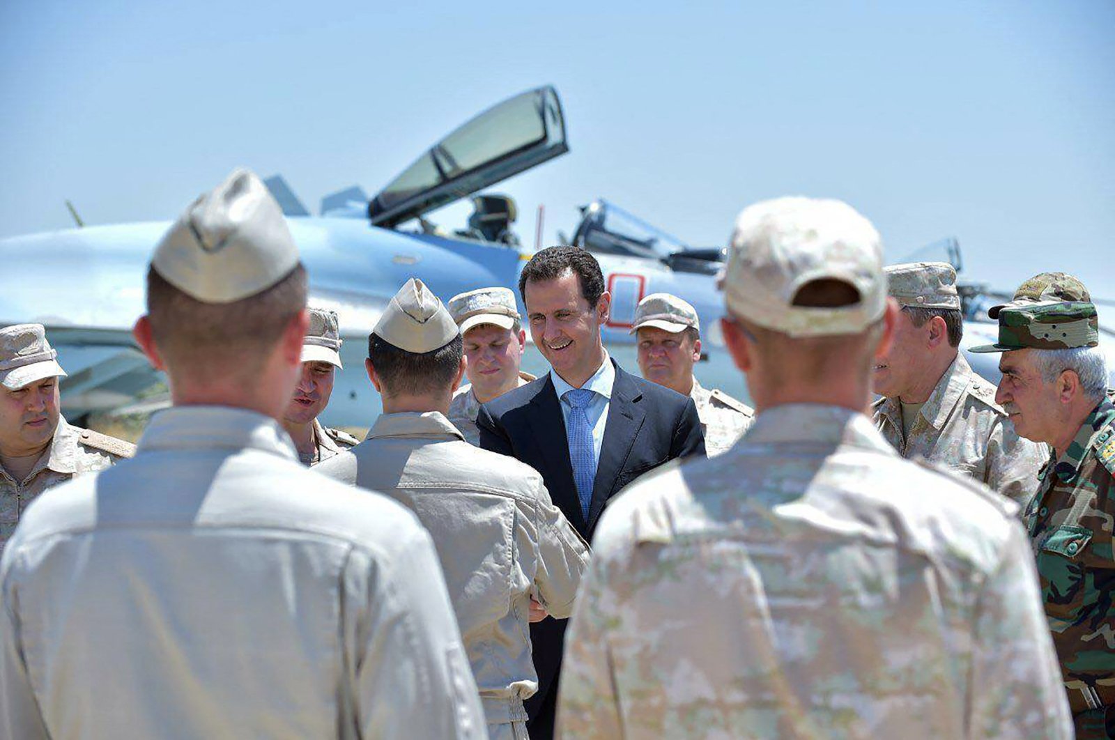  A handout picture released on the official Facebook page of the Syrian Presidency on June 27, 2017, shows President Bashar Assad (C) being welcomed by a Russian soldier during his visit to the Hmeimim military base in Latakia province, in the northwest of Syria. The Paris appealS court validated on June 26, 2024an arrest warrant for Syrian President Bashar Assad that France issued last year for alleged complicity in war crimes during Syria&#039;s civil war, according to plaintiffs lawyers. (Photo by Syrian Presidency Facebook page / AFP)