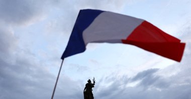 Protesters hold a French national flag as people gather to protest against the French far-right National Rally (RN) party, at the Place de la Republique following partial results in the first round of the early 2024 legislative elections, Paris, France, June 30, 2024. (Reuters Photo)