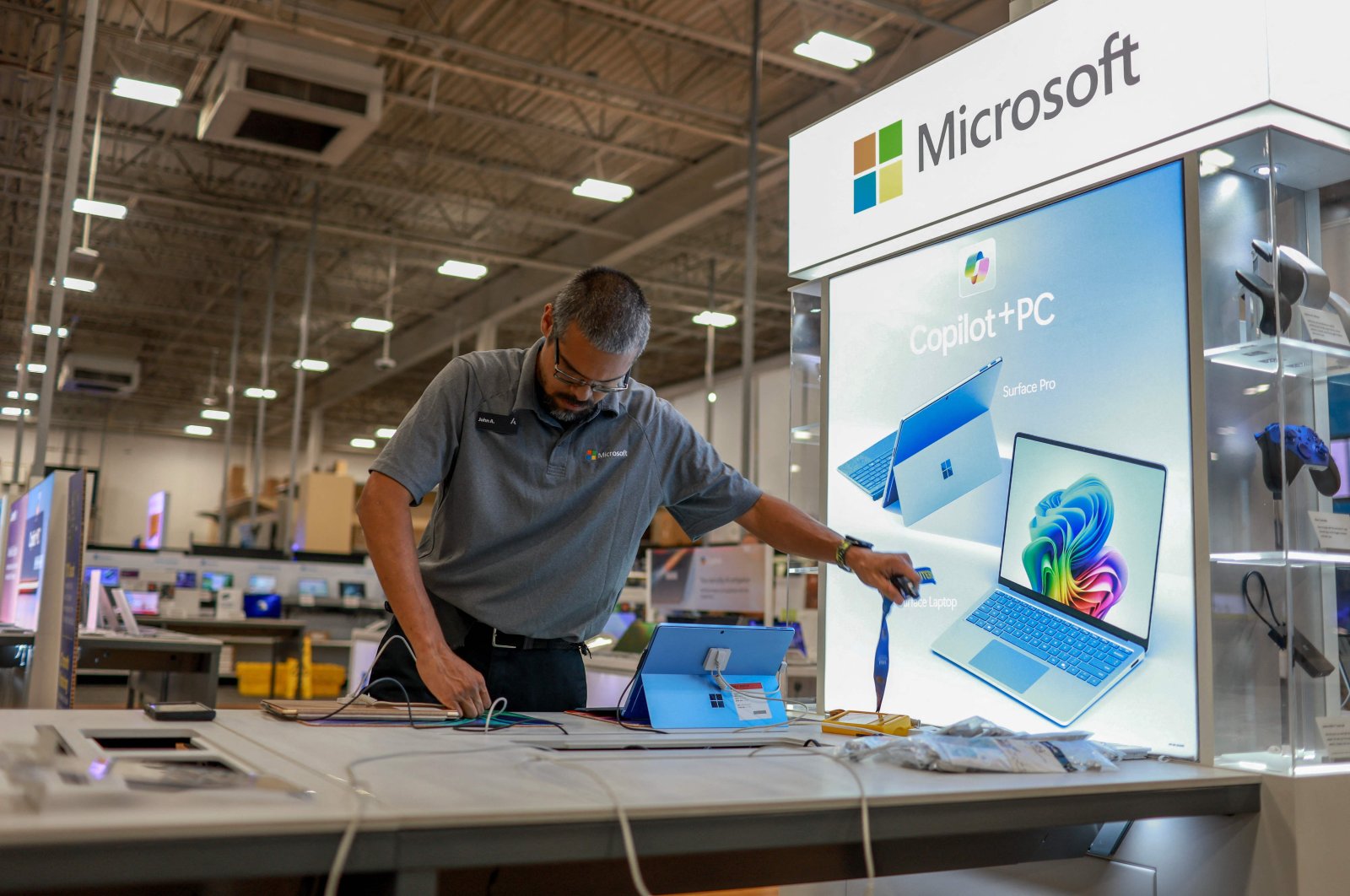 An employee builds a Microsoft Copilot  display at a Best Buy store as it begins selling Microsoft&#039;s new line of AI-centric Copilot  PCs to customers, Miami, Florida, U.S., June 18, 2024. (AFP Photo)