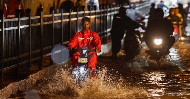 A delivery person rides an electric scooter in a waterlogged subway after heavy rains, Mumbai, India, July 8, 2024. (Reuters Photo)