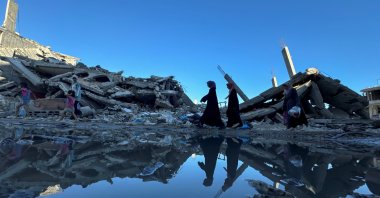
Palestinians walk past the rubble of houses destroyed in Israeli strikes, in Khan Younis in the southern Gaza Strip July 7, 2024. (Reuters Photo)