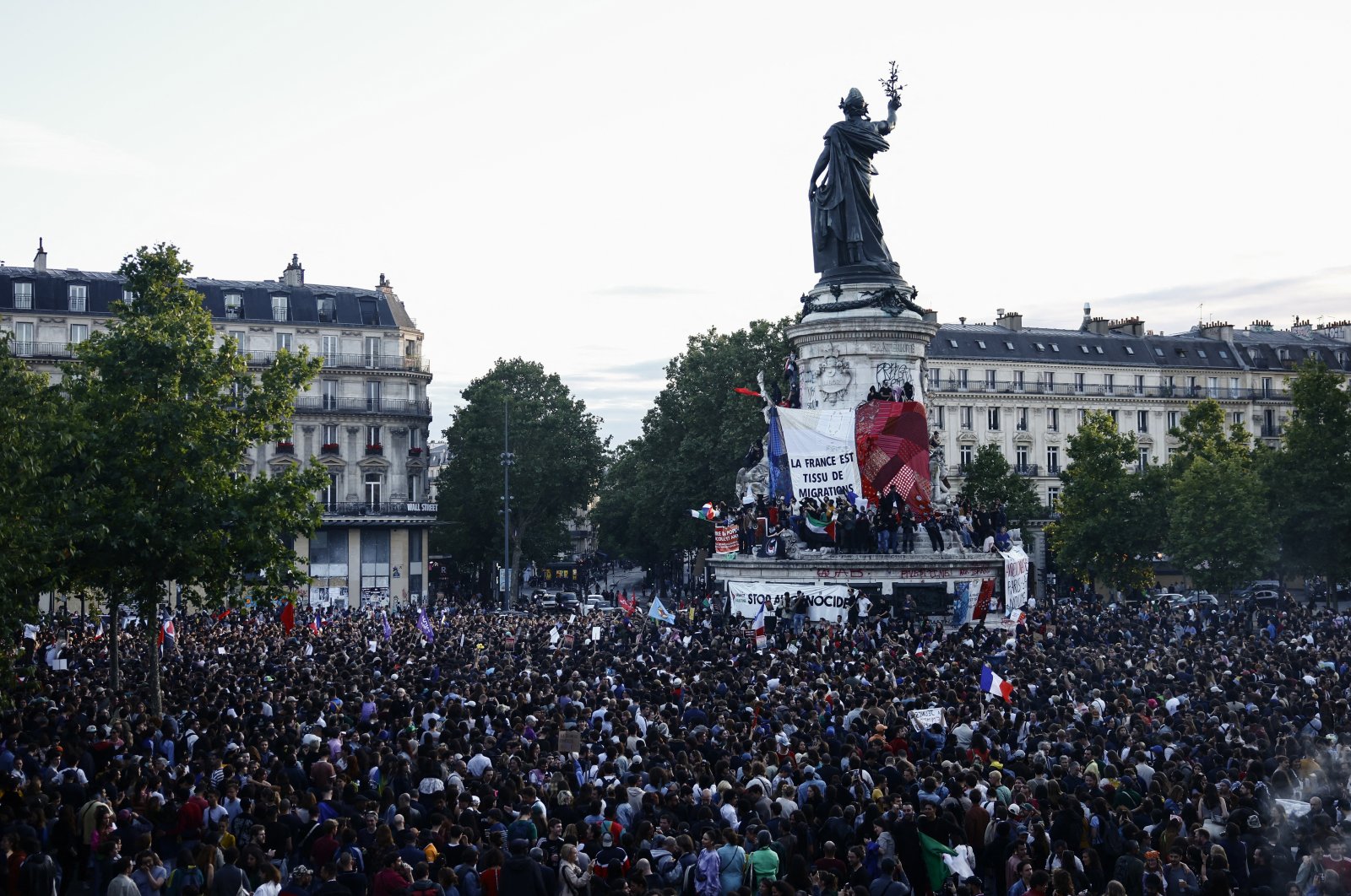 Protesters hold a giant French flag on the statue of Marianne as people gather at the Place de la Republique after partial results in the second round of the early French parliamentary elections, Paris, France, July 7, 2024. (Reuters Photo)