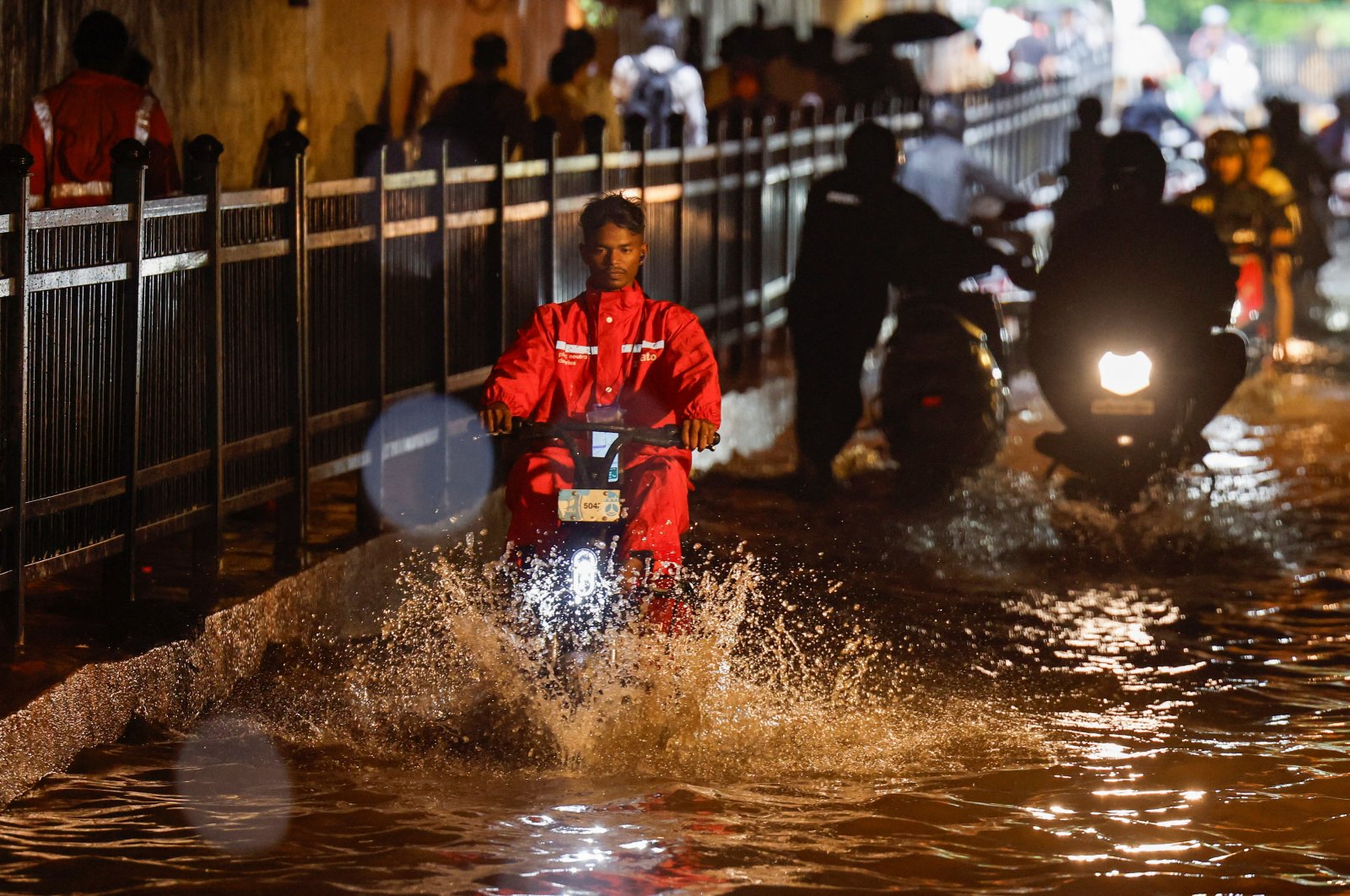 A delivery person rides an electric scooter in a waterlogged subway after heavy rains, Mumbai, India, July 8, 2024. (Reuters Photo)