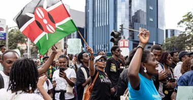 A woman waves a Kenyan flag while marching against the Finance Bill 2024 in downtown Nairobi, Kenya,  June 23, 2024. (AFP Photo)