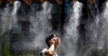 A man takes a break under a cooling mist in Tokyo, Japan July 9, 2024. (Reuters Photo)