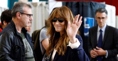 French singer Carla Bruni (C) waves her hand in a polling station during the vote of the second round of France&#039;s legislative election, Paris, July 7, 2024. (AFP Photo)