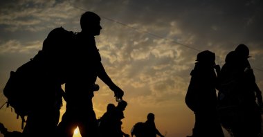A silhouette of immigrants walking before sunset. (Getty Images Photo)