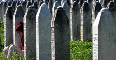 A Bosnian Muslim woman sits among headstones as she prays next to graves of her relatives, Srebrenica, Bosnia-Herzegovina, July 11, 2024. (AFP Photo)