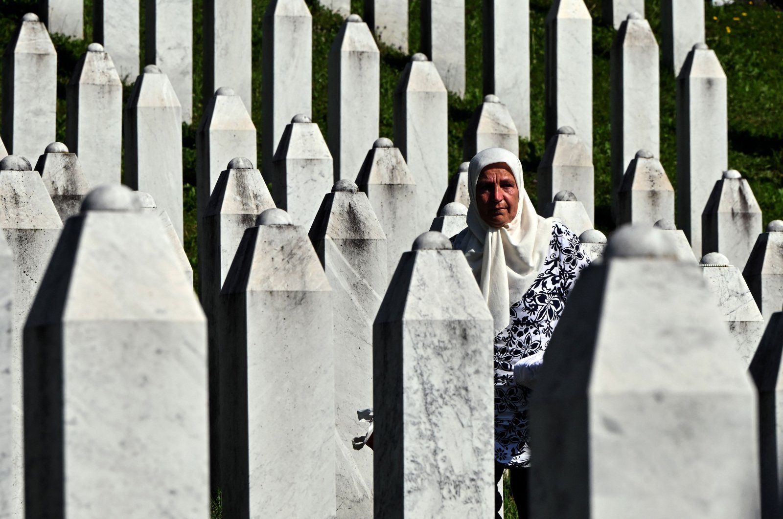 Bosnian Muslim survivor of the 1995 Srebrenica genocide stands among headstones at the memorial cemetery in village of Potocari, Srebrenica, Bosnia, July 11, 2024. (AFP Photo)