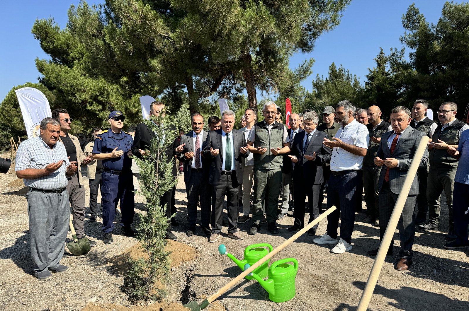 Attendees plant trees and offer prayers in honor of the July 15 coup attempt martyrs during a ceremony, Izmir, western Türkiye, July 11, 2024. (AA Photo)