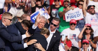 Republican presidential candidate and former U.S. President Donald Trump gestures with a bloodied face while he is assisted by U.S. Secret Service personnel after he was shot in the right ear during a campaign rally at the Butler Farm Show, Butler, Pennsylvania, U.S., July 13, 2024. (Reuters Photo)