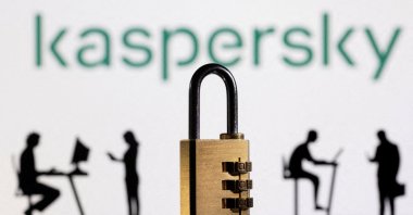 3D printed models of people working on computers and a padlock are seen in front of a displayed Kaspersky logo in this picture illustration created Feb. 1, 2022. (Reuters Photo)