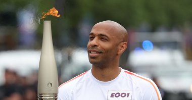 French football Olympics 2024 coach Thierry Henry holds the Paris 2024 Olympic flame as the Olympic Torch Relay arrives, Paris, France, July 14, 2024. (EPA Photo)