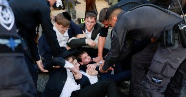 Young men lay on the ground, as Ultra-Orthodox Jewish men protest after an Israeli Supreme Court ruling that requires the state to begin drafting ultra-Orthodox Jewish seminary students to the military, in Bnei Brak, Israel July 16, 2024. (Reuters Photo)