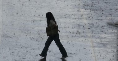 A woman walks in heavy rainfalls in Erzurum, Türkiye, June 7, 2024. (DHA Photo)