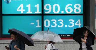 Pedestrians walk past a display showing the closing information of the Nikkei Stock Average, Tokyo, Japan, July 12, 2024. (EPA Photo)