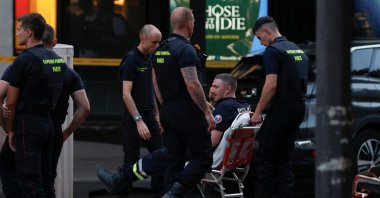 A member of police sits in a wheelchair after a police officer was injured in an attack next to the Champs-Elysees avenue, in Paris, France, July 18, 2024. (Reuters Photo)
