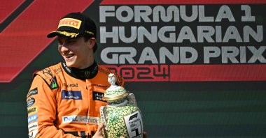 Winner Team McLaren-Mercedes&#039; Oscar Piastri celebrates on the podium with the trophy after the Formula One Hungarian Grand Prix at the Hungaroring race track in Mogyorod, Budapest, Hungary, July 21, 2024. (AFP Photo)