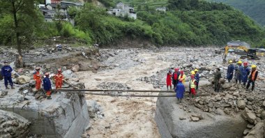 Rescue workers set up a temporary crossing after floods in the Hanyuan County of Sichuan Province, southwest China, July 20, 2024. (AP Photo)