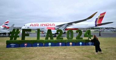 A visitor takes a photograph of a FIA2024 logo in front of an Air India Airbus A300 on the opening day of the Farnborough International Airshow 2024, southwest of London, Britain, July 22, 2024. (AFP Photo)