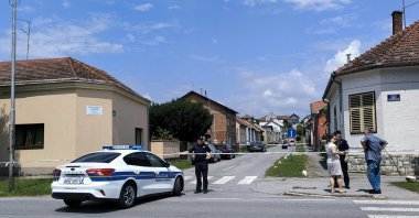 A police officer stands guard behind a police tape next to a retirement home where at least five people were killed in a shooting in Daruvar, Croatia, July 22, 2024. (AFP Photo)