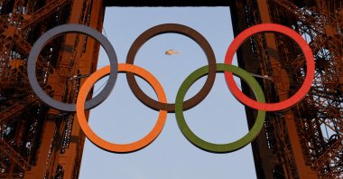 A helicopter flies around the Eiffel Tower with the Olympic rings displayed on it ahead of the Paris 2024 Olympic and Paralympic Games, Paris, France, July 21, 2024. (AFP Photo)