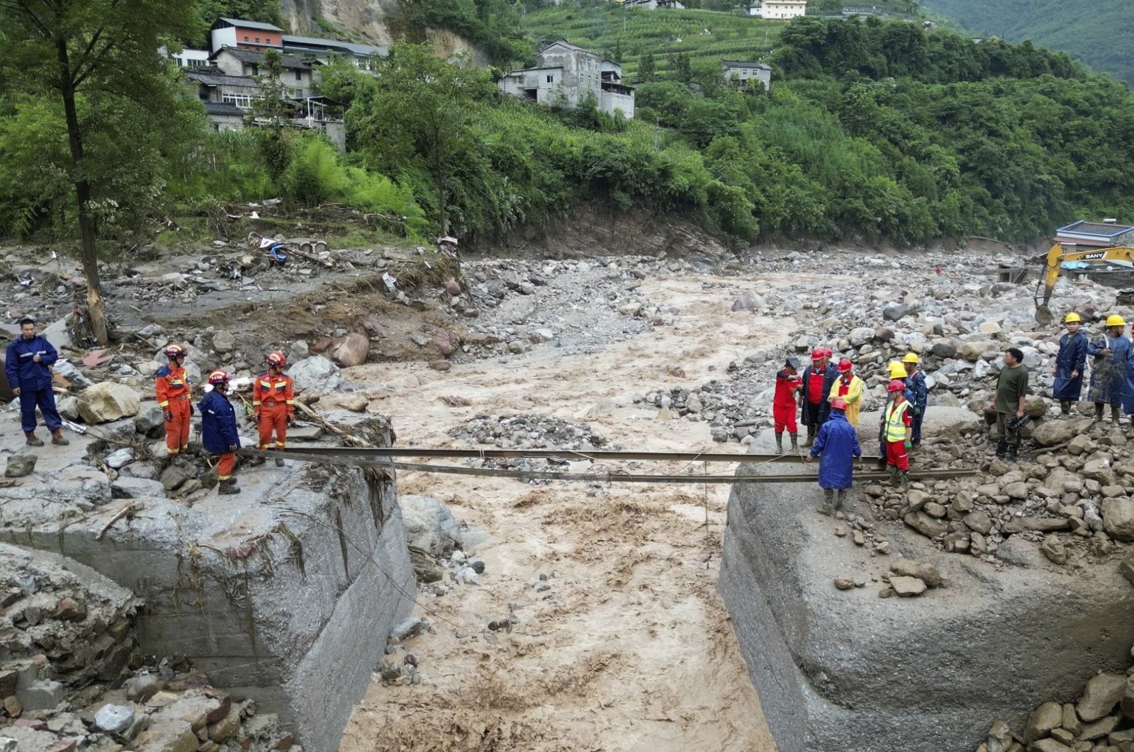 Rescue workers set up a temporary crossing after floods in the Hanyuan County of Sichuan Province, southwest China, July 20, 2024. (AP Photo)